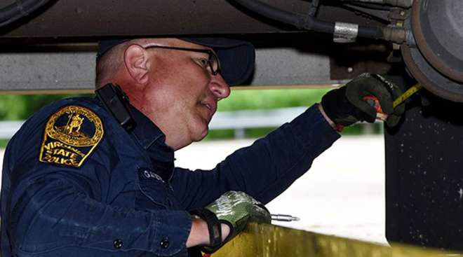 CVSA inspector checking brakes